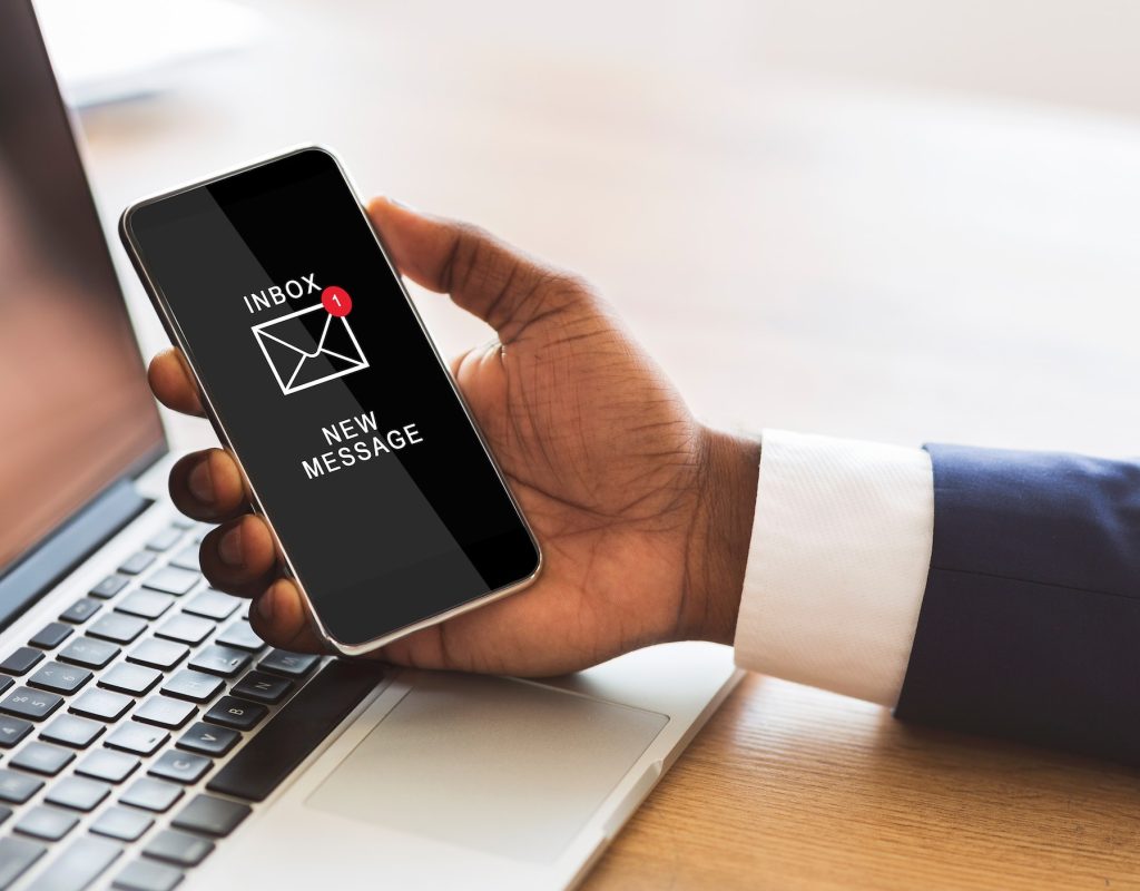 Black Businessman Holding Smartphone Reading E-Mail Message In Office