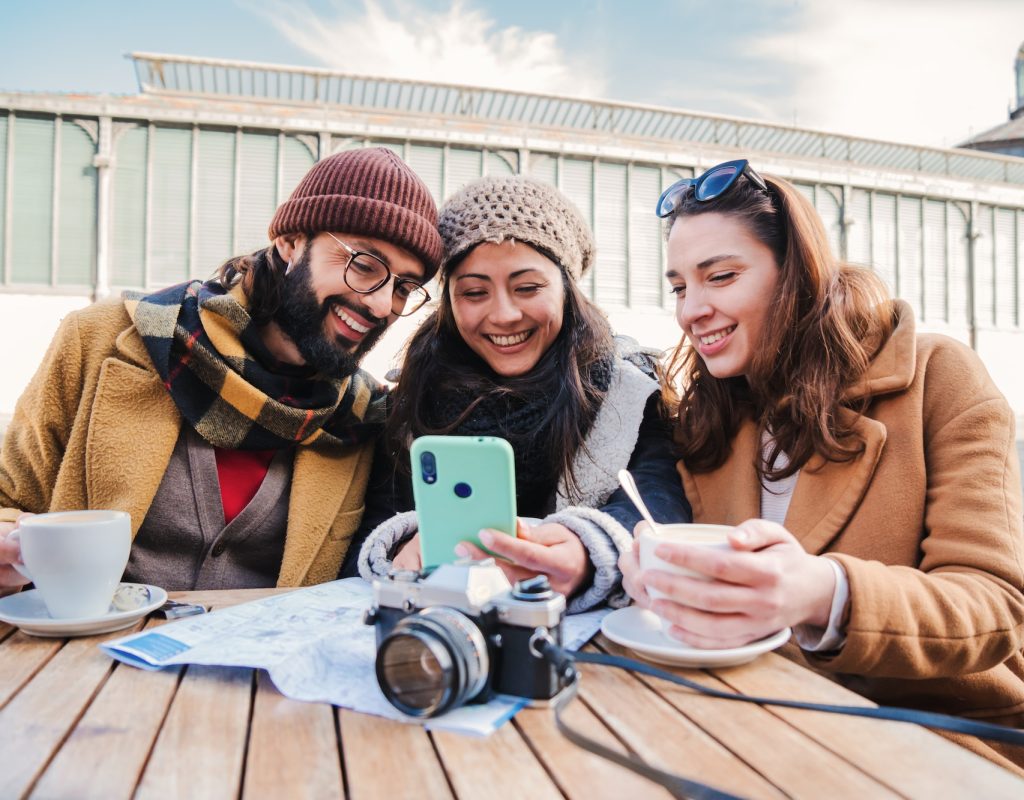 Group of young friends having fun watching videos on a social media app using a cellphone device it