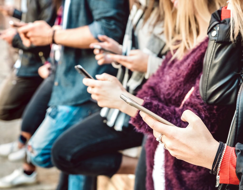 Shallow view of friends hands sharing content on mobile cell phones